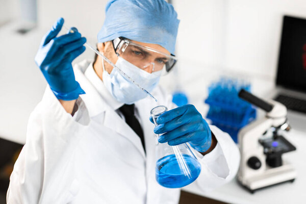 close up. scientist studying the liquid in a medical flask.