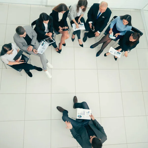 Vista superior. o gerente realiza uma reunião com a equipe de negócios. — Fotografia de Stock