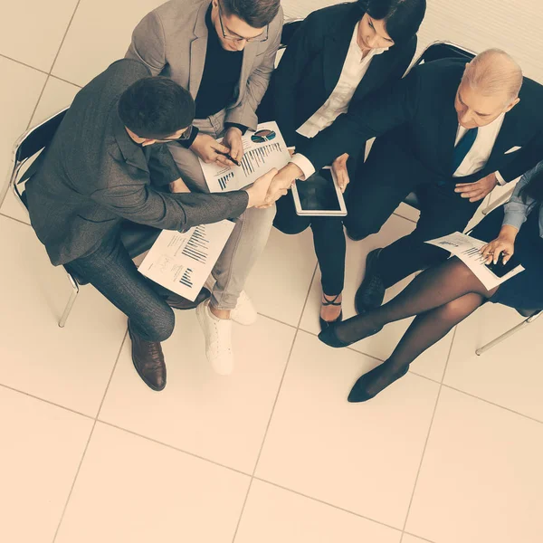 Vista dall'alto. un gruppo di uomini d'affari che discutono documenti aziendali — Foto Stock