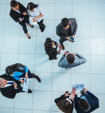 Üst Manzara. Toplantıdan önce finansal verileri tartışan çalışanlar.