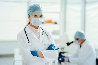 Kapat. Laboratuvarda steteskoplu bir doktor duruyor..