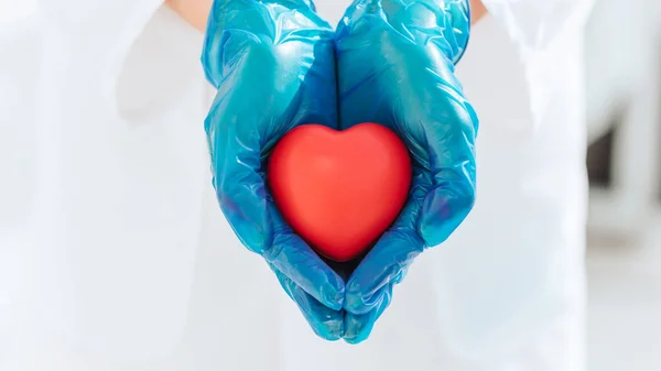 Doe dicht. klein hart in de veilige handen van een arts . — Stockfoto