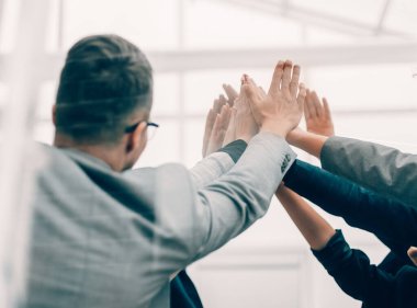 Kapat. Bir grup genç çalışan birbirlerine beşlik çakıyor..