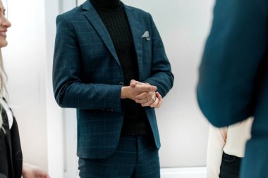 Kapat. Ofiste dikilen bir grup iş adamı konuşuyor.