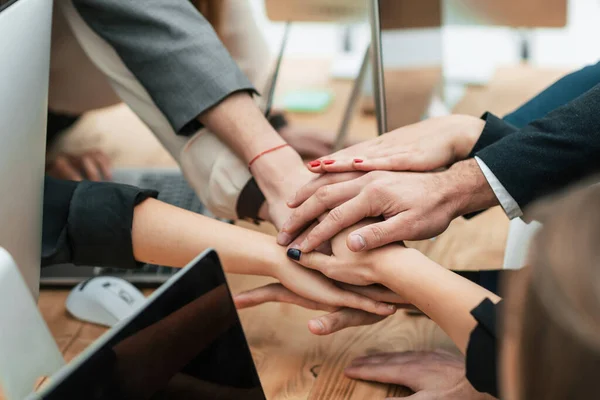 De cerca. equipo de negocios uniendo sus manos sobre el escritorio. — Foto de Stock