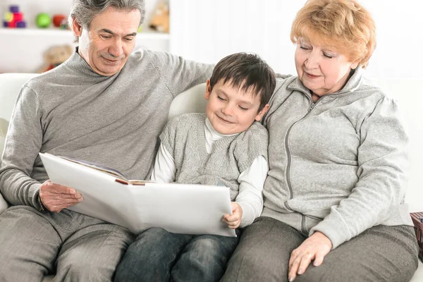 Loving grandparents with grandchild sitting on sofa — Stock Photo, Image