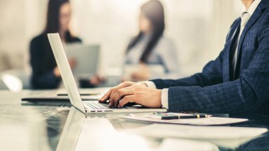 Modern bir ofisteki işyerinde finansal verilerle çalışan başarılı bir iş adamı..