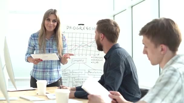 Jovem empresária compartilha boas notícias com colegas em uma reunião de escritório. — Vídeo de Stock