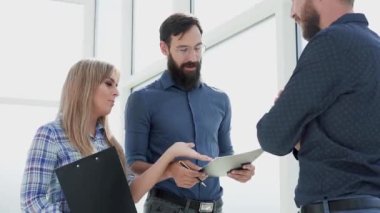 Ofis lobisinde iş konularını tartışan çalışanlar.
