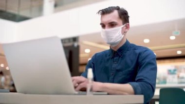 Bir kafede dizüstü bilgisayarla çalışan serbest çalışan bir adam. .