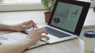 Kapat. İş adamı finansal verileri analiz etmek için bir dizüstü bilgisayar kullanıyor.