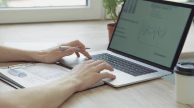 Bir dizüstü bilgisayardaki yeni bir projenin istatistiklerini analiz eden girişimci .