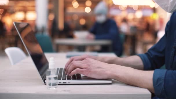 Zblízka. návštěvník internetové kavárny, pracující na notebooku . — Stock video