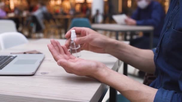 Uomo disinfettando le mani prima di lavorare su un computer portatile. — Video Stock