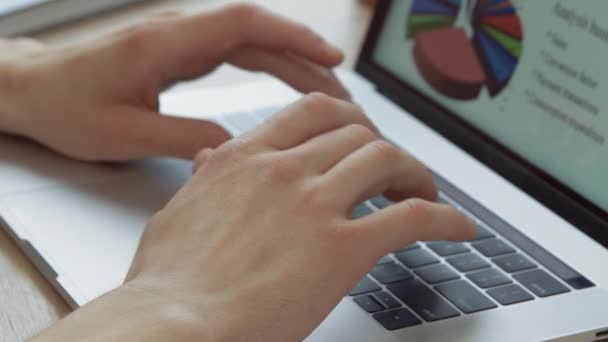 Бизнесмен работает на ноутбуке с финансовыми столами. — стоковое видео