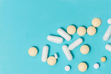 Kapat. Masanın üzerinde ilaç ve tabletler olan kapsüller.