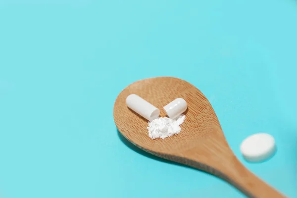 Close up. capsule with medicine in a wooden spoon. — Stock Photo, Image
