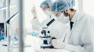 Kapat. Laboratuarda mikroskop kullanan bir bilim adamı. .