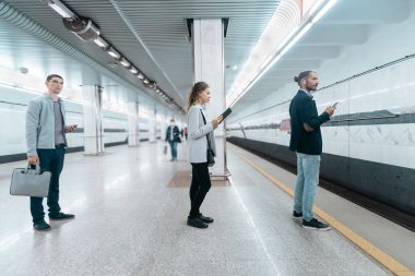 Metro yolcuları platformda treni bekliyorlar..
