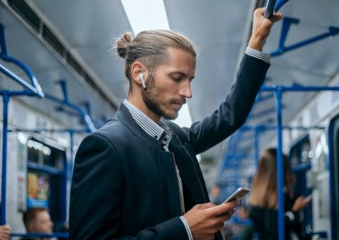 İşadamı metroda e-postalarını okuyor..