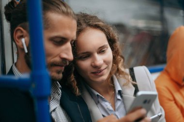 Genç çift akıllı telefon ekranlarına bakıyor. .