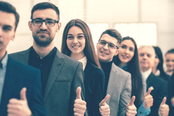 Group of young entrepreneurs standing together and giving a thu — Stock Photo, Image