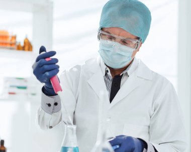 Kapat. Laboratuvar şişesinde sıvı testi yapan bir bilim adamı..