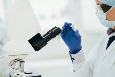 Hırslı bilim adamı yeni bir ilaçla ampulü inceliyor..