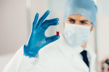 Kapat. Bir bilim adamının elinde aşı olan ampul..