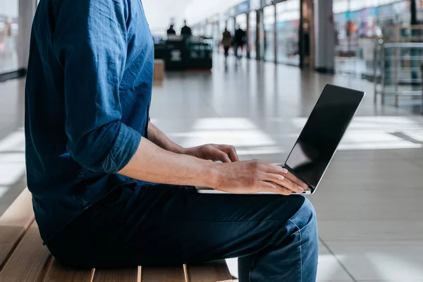 Homem em máscara protetora usando um laptop em uma rua da cidade — Fotografia de Stock