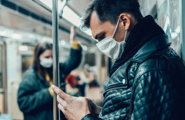 Passageiro em uma máscara protetora lendo uma mensagem em seu smartphone. — Fotografia de Stock