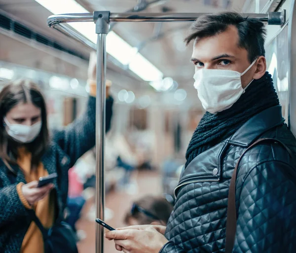 Passageiros em máscaras de proteção de pé no carro do metrô. — Fotografia de Stock