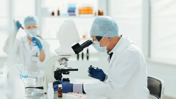 Cientista usando um microscópio em um laboratório bioquímico. — Fotografia de Stock