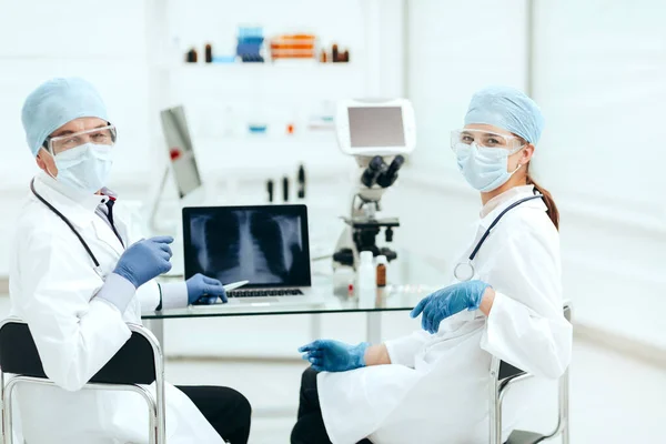 På nära håll. medicinska kollegor som sitter vid ett bord i laboratoriet . — Stockfoto