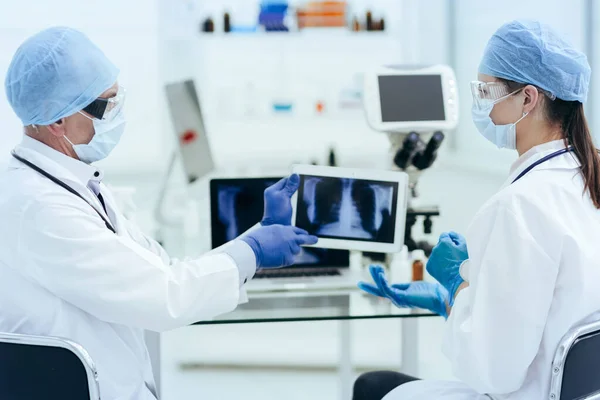 Tıbbi meslektaşlar dijital tablet ekranda röntgen çekmeyi tartışıyor. — Stok fotoğraf