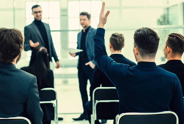 employee asks a question during a business seminar