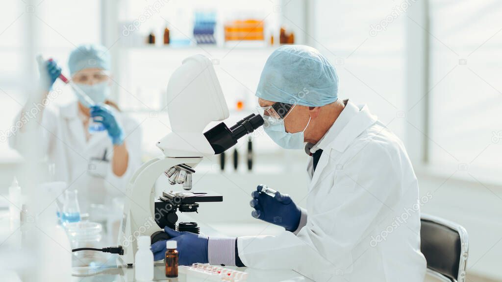 scientist using a microscope in a biochemical laboratory.