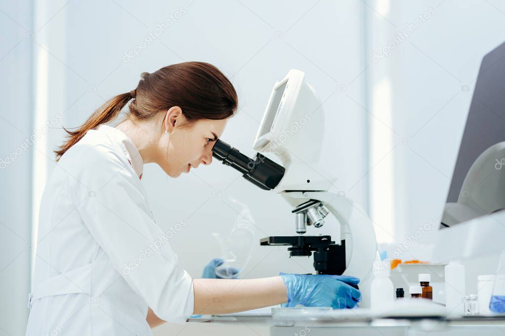 close up. female scientist using a microscope in the lab.