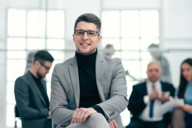 Ofiste duran kendine güvenen bir iş adamı.