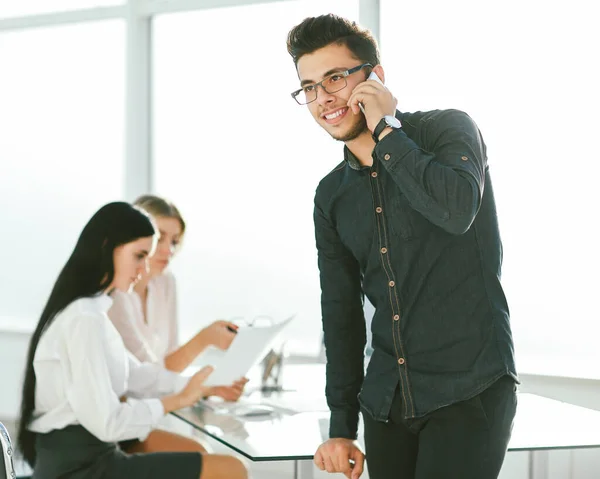 Jungunternehmer spricht im Büro auf seinem Smartphone — Stockfoto