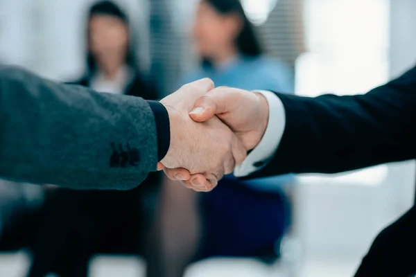 Apretón de manos de negocios firme en un fondo borroso de oficina. — Foto de Stock