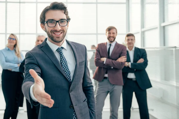 Friendly businessman holding out his hand for a handshake — Stock Photo, Image