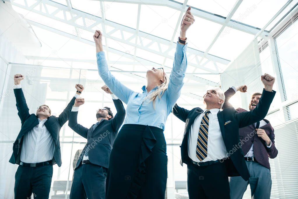 jubilant business woman standing in front of her colleagues