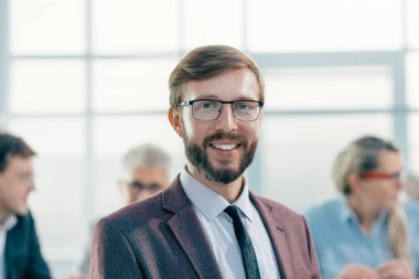 Kapat. Gülümseyen iş adamı ofiste duruyor.