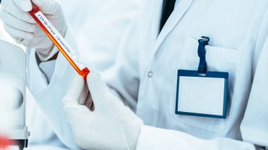 Test tüpüne bakan bir bilim adamının görüntüsü .