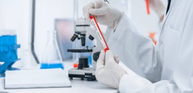 Kapat. Laboratuvar çalışanı laboratuvar masasında oturuyor.