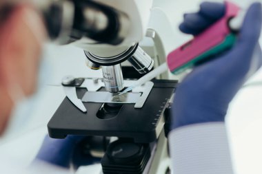 Kapat. Laboratuarda mikroskop kullanan bir bilim adamı..