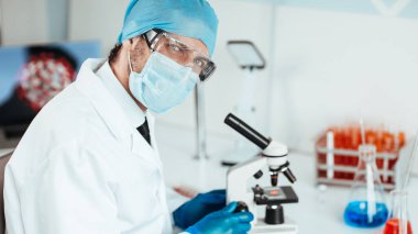 Laboratuvardaki bir masada oturan yetenekli bir bilim adamı..