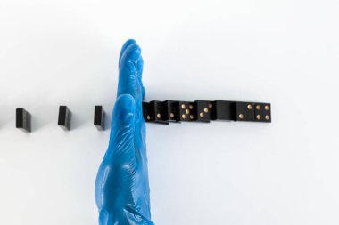 Kapat. Doktor koruyucu eldiven takıyor, domino oynuyor. Sağlık kavramı.