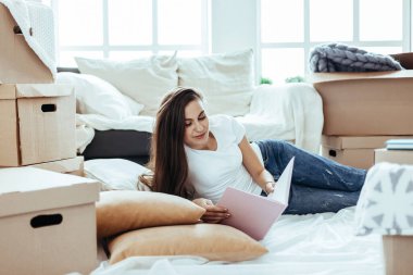 Genç bir kadın yeni evinin tasarımına bakıyor..